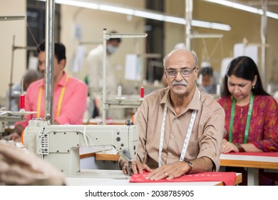 Indian Man Sewing Clothes With Sewing Machine At Textile Factory