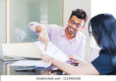 Indian Man Showing Fact Sheet With Graphs To A Woman