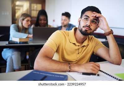 Indian man, student and bored in classroom, tired and stress with notes, examination or task. Young male, guy or exhausted for education, test or notes for assignment with headache and depressed - Powered by Shutterstock