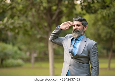 Indian man in suit and saluting at park - Powered by Shutterstock