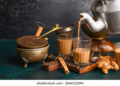 Indian Masala Chai Spice Tea Being Poured With Kettle, With Samosa And Spices On Dark  Background. Cafe, Bar, Ethnic, Food, Restaurant, Hotel Concepts.