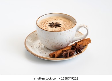 Indian Masala chai tea. Traditional Indian hot drink with milk and spices on white background close up.