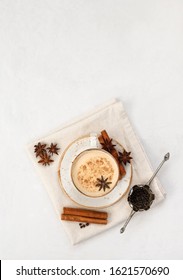 Indian Masala chai tea. Traditional Indian hot drink with milk and spices on white concrete background. Top view, flat lay. Copy space.