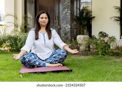 Indian Mature woman doing yoga at home garden - Powered by Shutterstock