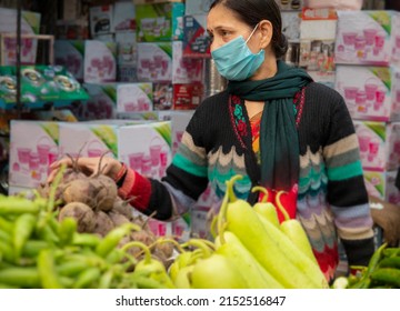 Indian Mature Woman Wearing Protective Face Mask And Buying Vegetables From Outdoor Market During The Third Wave Of Coronavirus, COVID-19 Pandemic Outbreak In Indian.    