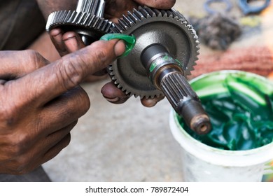 Indian mechanic applying grease
