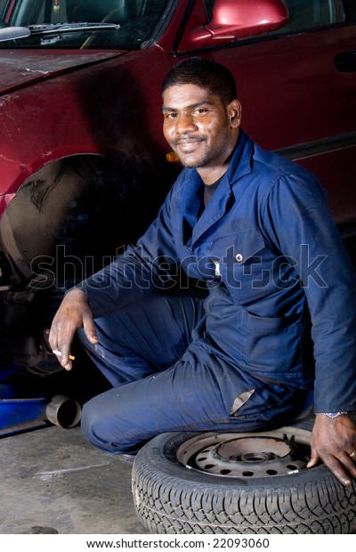 indian mechanic changing\
vehicle tire