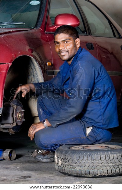 indian mechanic changing\
vehicle tyre