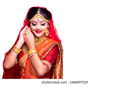 Indian model in traditional Indian bridal makeup and wedding dress on white background