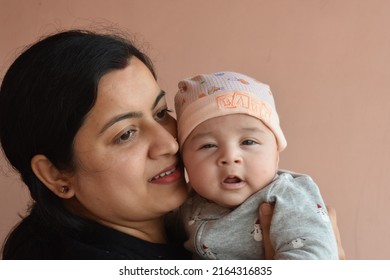 Indian Mom And Son. Mother Embracing The Infant Baby, Who Look At Camera With Serious Facial Expression Healthcare And Medical Love Asia Woman Lifestyle Mother's Day Concept .