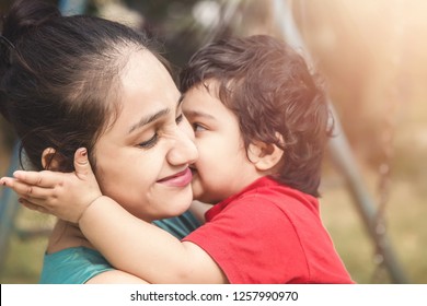 Indian Mother And Baby Smiling Together. Love. Happy Cheerful Family Mom And Baby Girl Kissing And Hugging Outdoor. Beautiful Healthy Mother And Little Daughter.Parenthood.