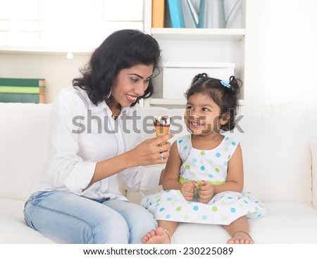 indian mother and child enjoying ice cream indoor