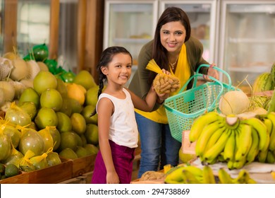 Indian Mother And Daughter Buying Sweet Tamarind Fruit At The Grocery Store