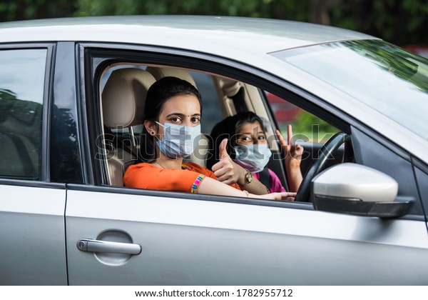 Indian Mother Daughter wearing Face Mask or medical\
mask while driving car