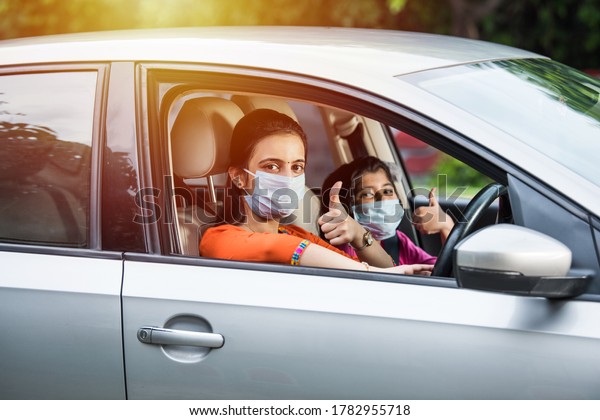 Indian Mother Daughter wearing Face Mask or medical\
mask while driving car