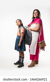 Indian Mother Helping School Girl With Uniform Getting Ready With Lunch Box, Hair Style Or Waiting For School Bus