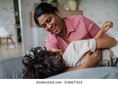 Indian Mother Hugging Her Little Son And Having Fun At Home.