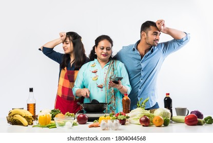 Indian Mother or Sister making food for young kids in kitchen
