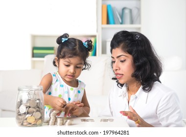 Indian Mother Teaching Daughter On Financial Planning Indoor