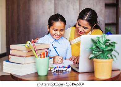 Indian mother teaching her little daughter drawing at home