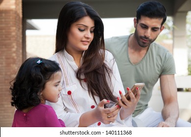 Indian Or Multi Ethnic Family , Mother Showing Something To Her Daughter On Phone Tablet