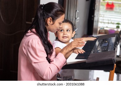 Indian Music Teacher Teaching Cute Little Kid How To Play Electronic Keyboard Or Piano. Mother Daughter Bonding. Leisure Activity. 