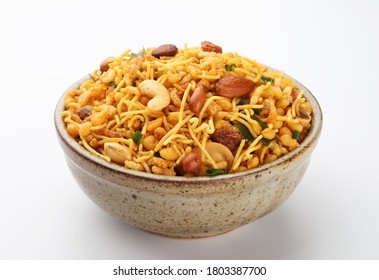 Indian Namkeen Snacks served in ceramic bowl & plate or Indian traditional Namkeen Food Mixture or Navratna Mix Namkeen Also Know as Nimco, Namkin, Mixture ,chiwda or Nimko

