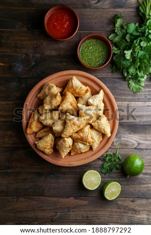 Indian o pakistani samosa in the women hands with sauce and lime      
