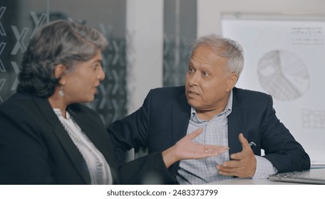 Indian old aged angry sad man woman sitting chair arguing dispute dealing client complaints at indoor job office. Elder upset boss male female employee fighting on bad bank insurance contract service - Powered by Shutterstock