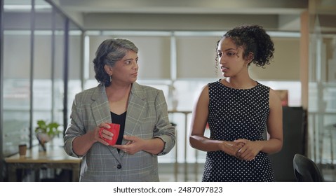 Indian old business women standing hold coffee cup mug serious gossip talk indoor work place. Beautiful young adult curly hair corporate girl blab share ideas during tea break spend time job enjoy day - Powered by Shutterstock