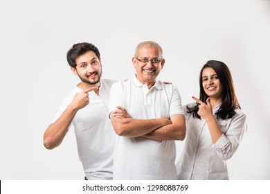 Indian old father embarrassing his young adult kids. Asian family of 3 standing isolated over white background. selective focus