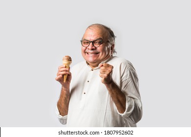 Indian Old Man Eating Chocolate Ice Cream In Cone Or Mango Candy Bar