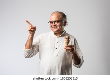 Indian Old Man Eating Chocolate Ice Cream In Cone Or Mango Candy Bar