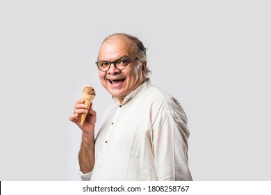 Indian Old Man Eating Chocolate Ice Cream In Cone Or Mango Candy Bar