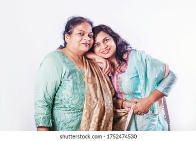 Indian Old Mother With Adult Daughter In Ethnic Clothes Posing For A Studio Shot, Looking At Camera, Smiling