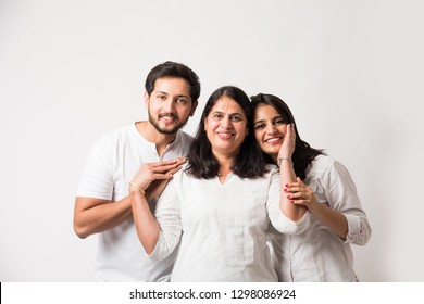 Indian old Mother embarrassing  young adult kids. Asian family of 3 standing isolated over white background. selective focus