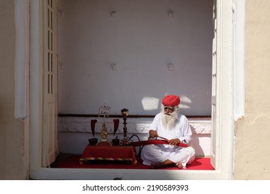 Indian Older Man With Beard, Red Hat, Sitting In Indian Streets, Jaipur, India, March 2019.