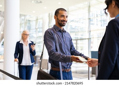 Indian passenger showing e-ticket to flight attendant at boarding gate. Young middle eastern businessman showing boarding pass on mobile phone to air hostess at airport. - Shutterstock ID 2147820695