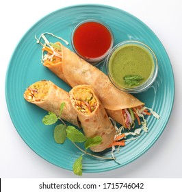 Indian popular snack food called Vegetable spring rolls or veg roll or veg franky made using paneer or cottage cheese and vegetables paratha/chapati/roti with  tomato ketchup.

