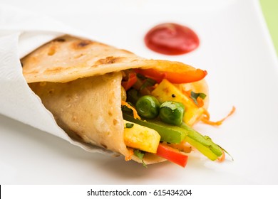 Indian popular snack food called Vegetable spring rolls or veg roll or veg franky made using paneer or cottage cheese and vegetables wrapped inside paratha/chapati/roti with tomato ketchup.