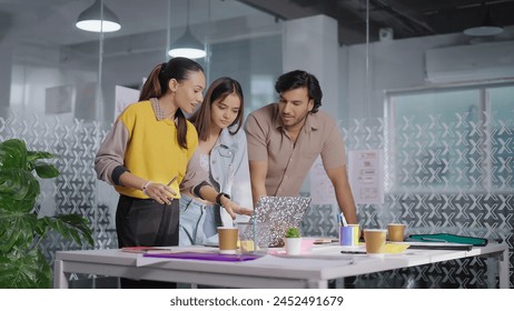 Indian professional business people standing at indoor job office use laptop listening project meeting discussion. Teenager female workers teach interns staff team group have communication do work  - Powered by Shutterstock