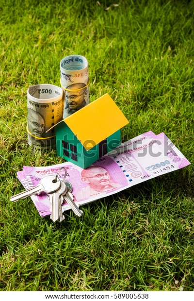 Indian Real estate business concept showing 3D\
model house with keys, paper currency notes and Calculator.\
Selective focus