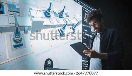 Indian Robotics Specialist Programs a Group of Robotic Arms with the Help of a Tablet Computer. Specialist Creates and Programs the Assembly Line Online, Optimizing Production and Improving Efficiency
