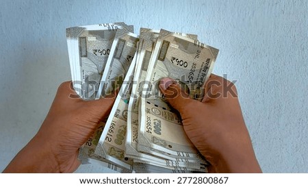 Indian Rupee currency notes held in hands, stack of five hundred rupee bills, concept of cash payment and financial wealth in India