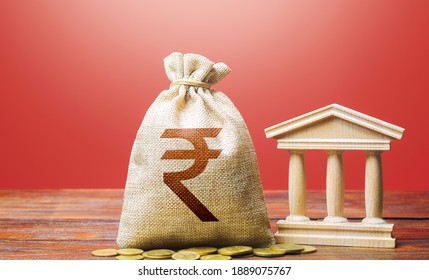 Indian Rupee Money Bag And Bank  Government Building. Tax Collection And Budgeting. GDP And GNP. Monetary Policy. Support Businesses In Times Of Crisis. Lending Loans, Deposits. State Debt.