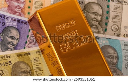 Indian rupee notes of different denominations of the Republic of India and a gold bar of 999 fineness