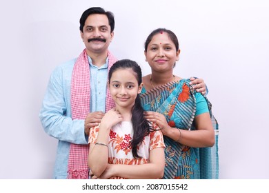 Indian rural happy family of father, mother and daughter portraying the child education concept standing together. Confident daughter is holding a writing board in hand. - Shutterstock ID 2087015542