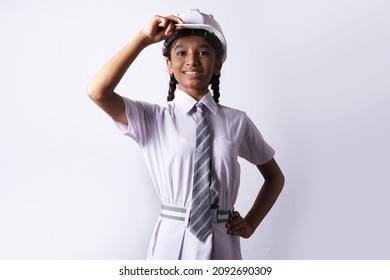 Indian Rural kid preparing herself to become an engineer in future. The rural girl is holding an engineering helmet portraying child education and grooming concept. - Shutterstock ID 2092690309