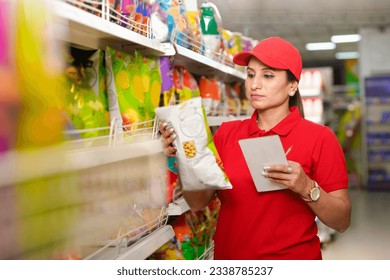 Indian saleswoman or manager checking stock at supermarket. - Powered by Shutterstock