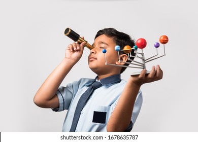 Indian School Kid / Boy Studying Planets Or Planetary Science With 3d Model Of Our Solar System